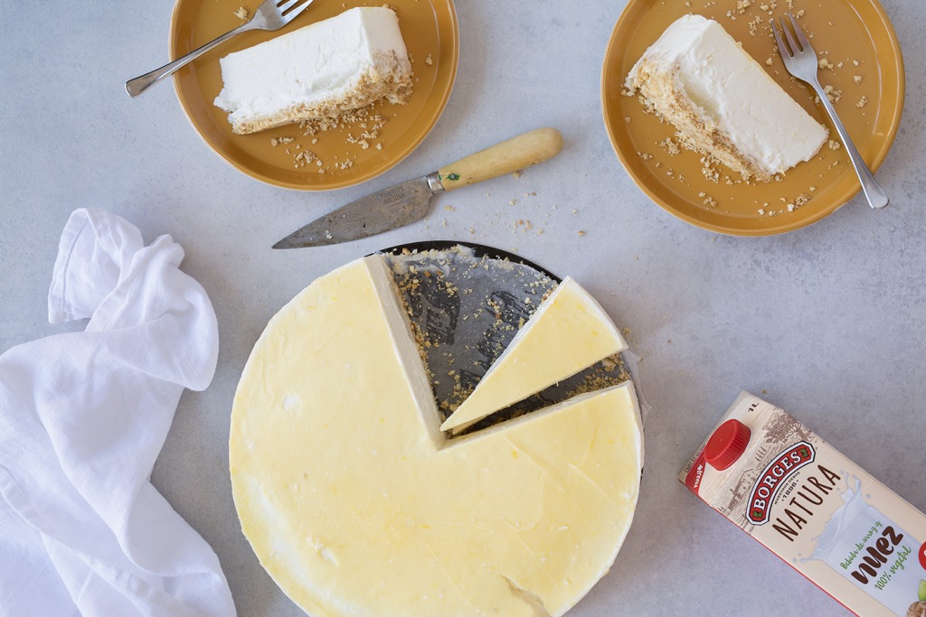 Receta de pastel de queso con limón cortado y con bebida de nueces
