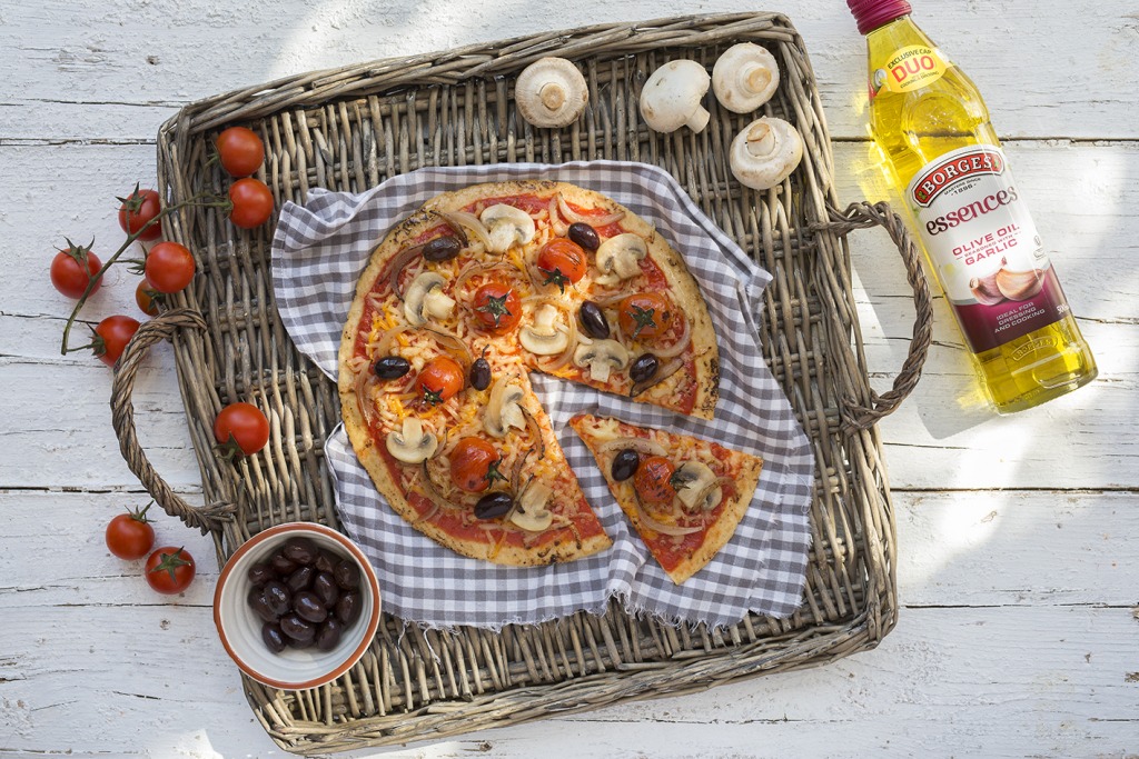 Pizza de champiñones y tomates frescos con un poco de aceite al ajo