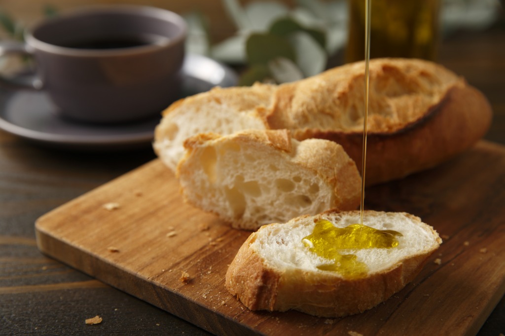 Incluir aceite de oliva en tu dieta diaria es importante como por ejemplo aceite con pan, como en esta imagen