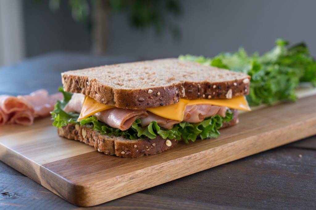 Sandwich de queso, lechuga y jamón con aceite. Un desayuno rápido y saludable
