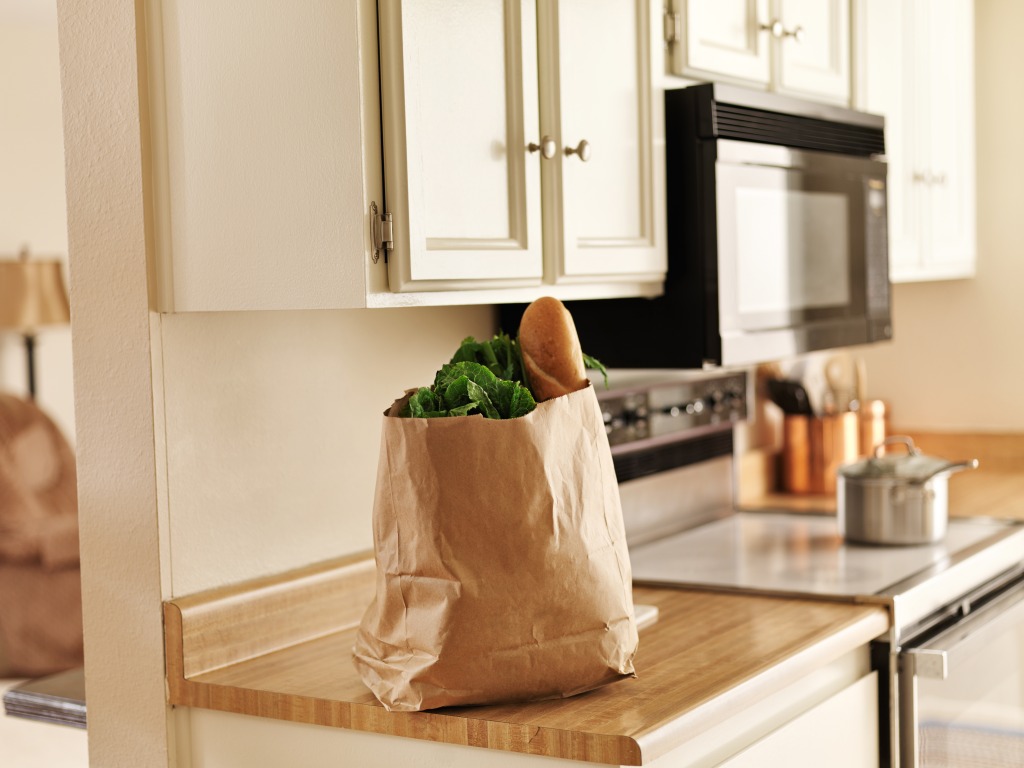 Prepara la despensa con alimentos como los que se ven en esta foto: verduras y pan sobre una encimera de la cocina