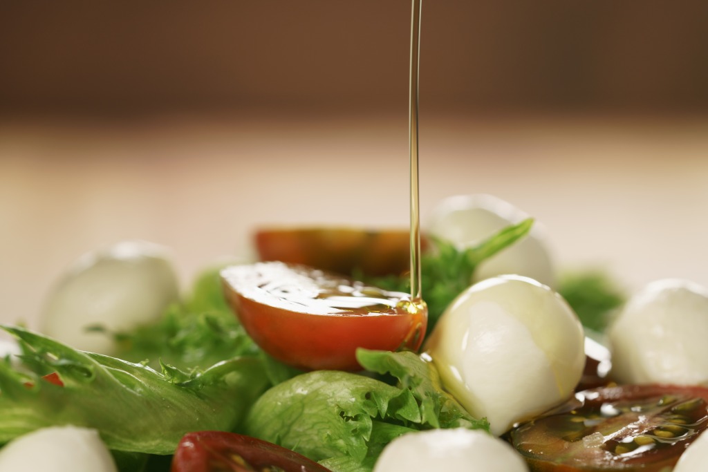 A splash of Borges olive oil falling on a salad
