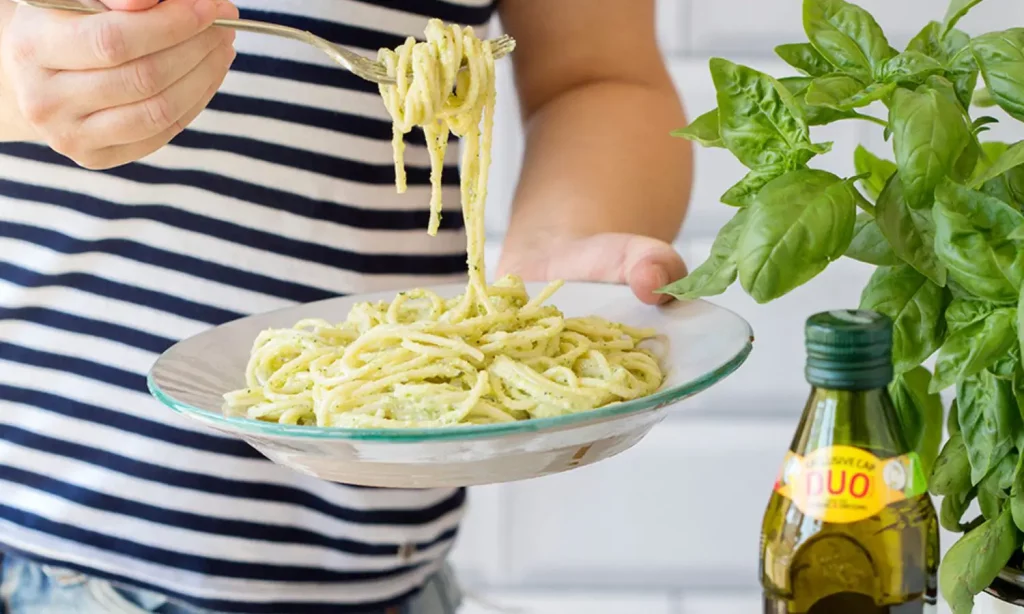 Spaghetti recipe served in a dish with a bottle of olive oil
