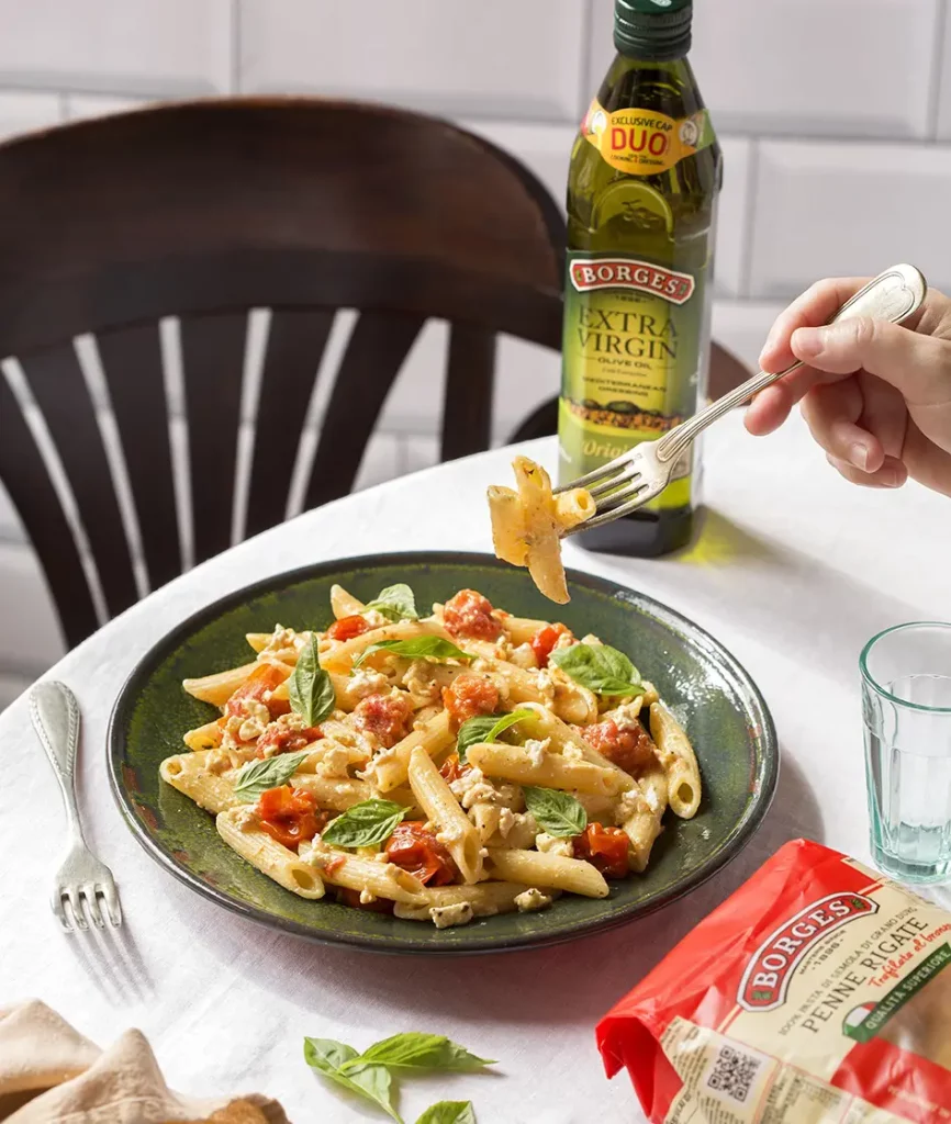 zapekané cestoviny na stole s flašou olivového oljea