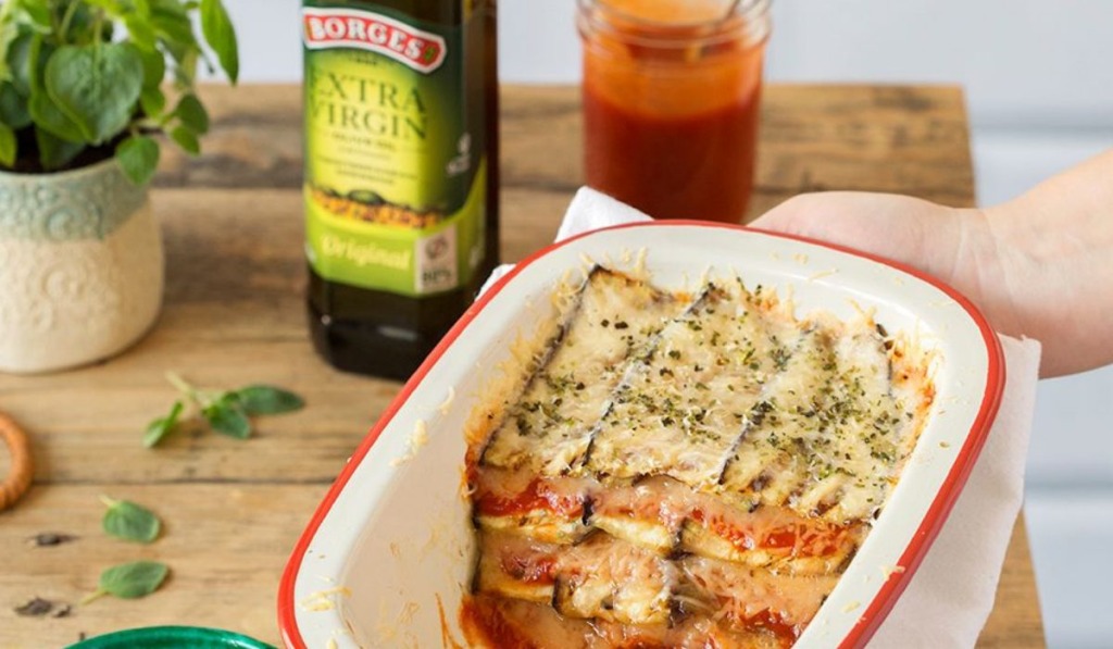 An oven-baked aubergine parmigiana served in a tray with extra virgin olive oil