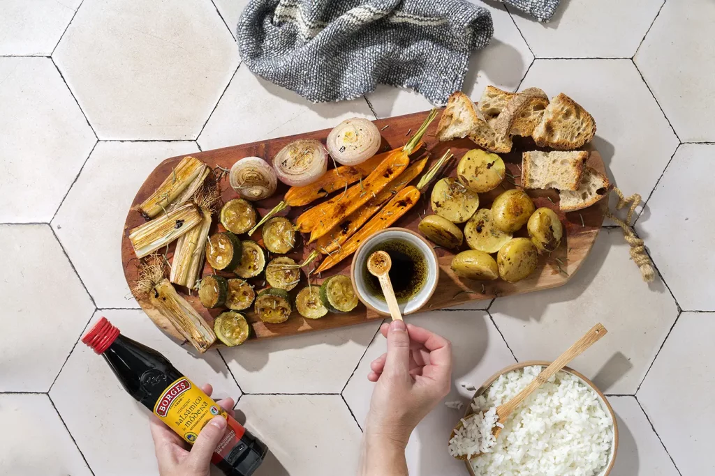 ruka dochucujúca zeleninu balsamicom