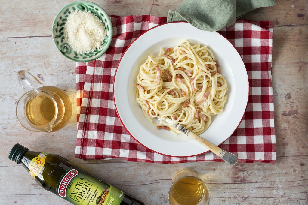 Spaghetti carbonara with no cream recipe served in a dish on a gingham print tablecloth