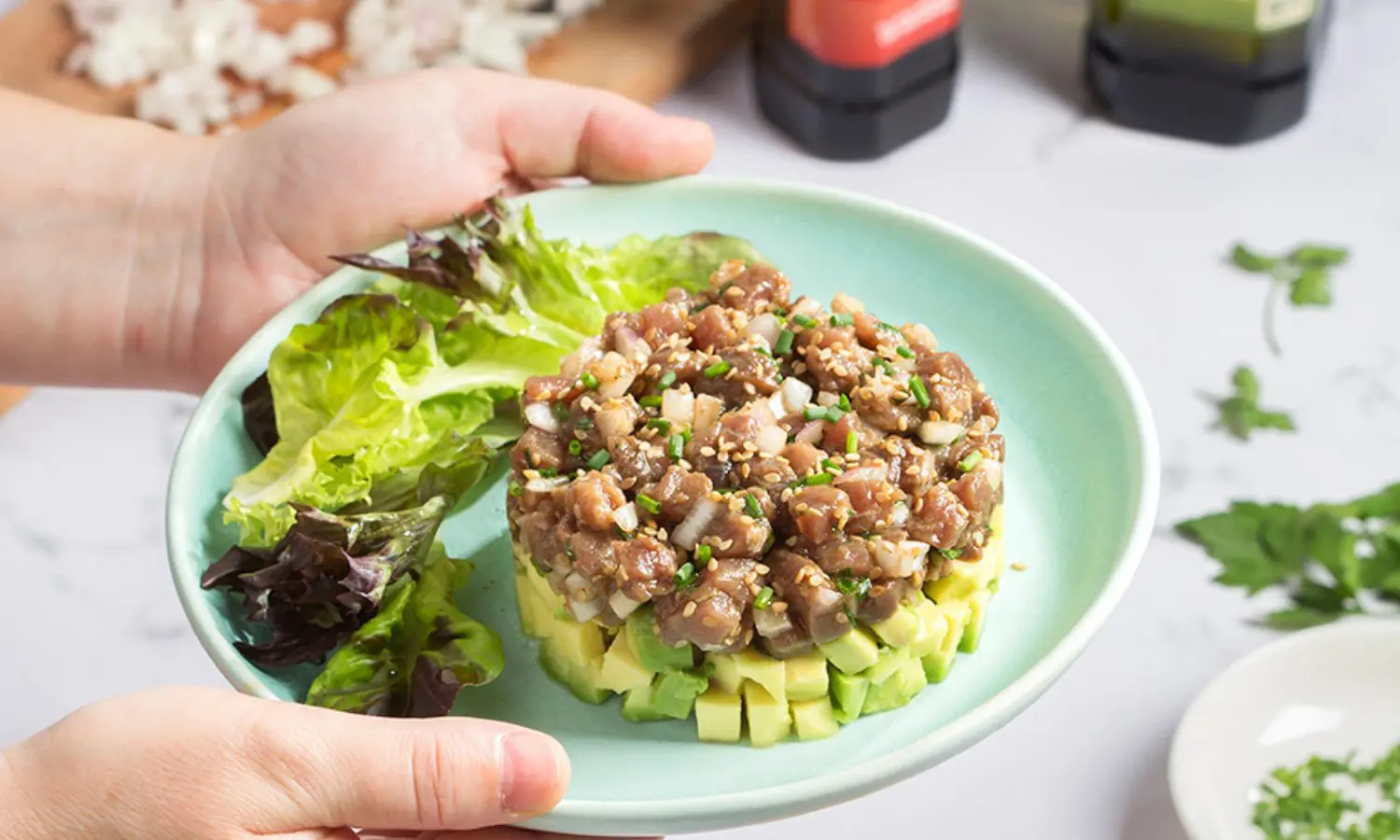 A tuna tartar and avocado recipe served with lettuce and sesame seeds