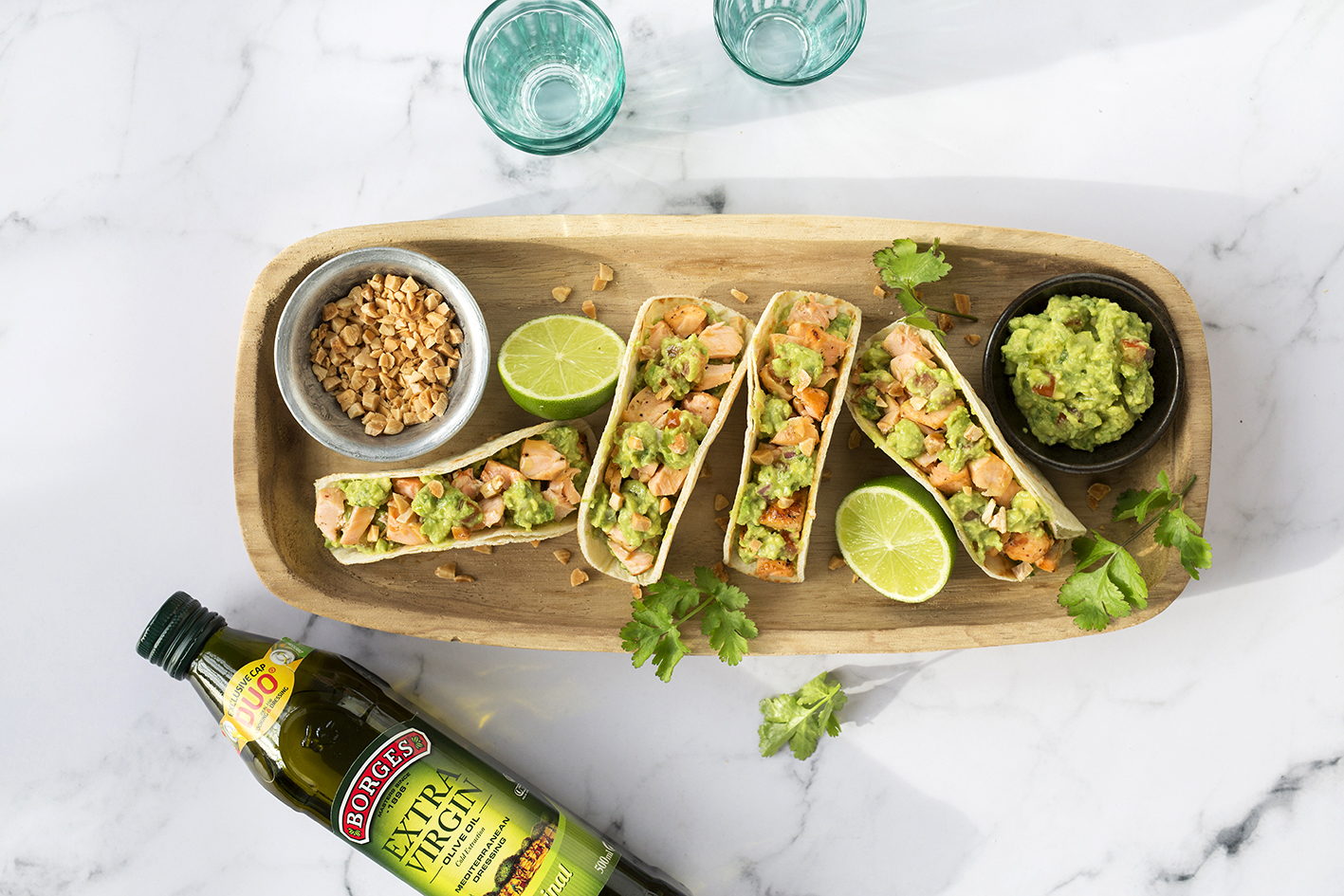 Salmon tacos with guacamole served on a wooden tray